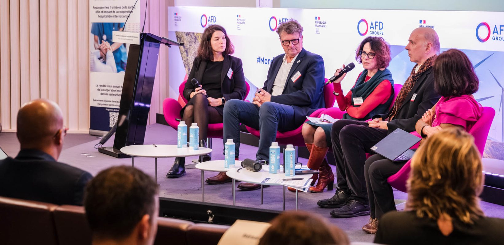 Cinq intervenants assis sur scène lors d’une table-ronde aux Journées de la Coopération Hospitalière Internationale 2025, avec un écran de présentation en arrière-plan.
